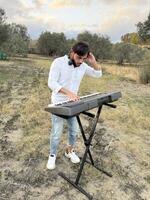 Boy Plays Keyboard In Nature In Calabria Countryside photo