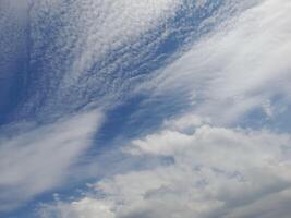 A breathtaking blue sky with a few fluffy clouds scattered here and there. photo