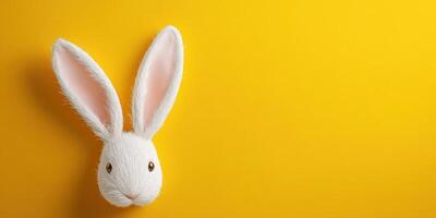 Cute white rabbit head against a bright yellow background with prominent ears and a friendly expression photo