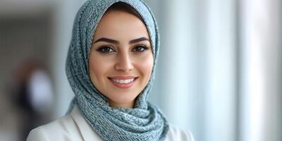 Smiling woman in a light scarf poses confidently in a bright indoor setting during daytime photo
