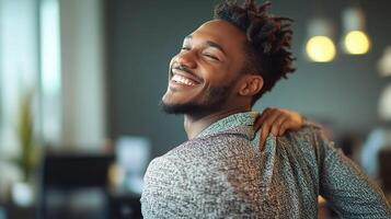 A man with dreadlocks smiling and holding his back photo
