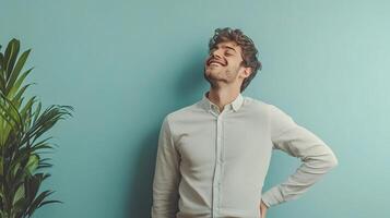 A man is standing in front of a plant and smiling photo