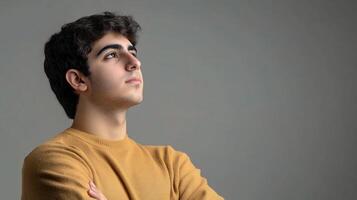 A young man with his arms crossed looking up photo