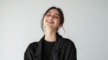 Stylish Female Model Smiling in Black Apparel Against Plain Background photo