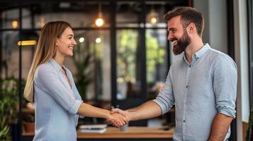 A man and woman shaking hands in an office photo