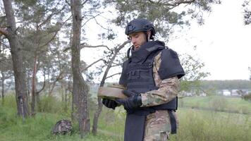Man in a special suit works with a detector and found an explosive device. A man tries to neutralize an anti-tank mine video