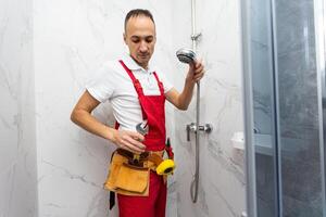 Plumber installing a shower cabin in bathroom photo