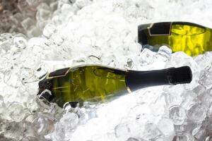 champagne bottles in a bucket with ice, top view photo