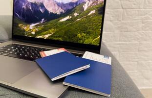 travel and vacation concept. top view of airplane, plane, laptop, passport and tickets on the table photo