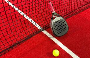 professional paddle tennis racket with natural lighting on red background. Horizontal sport theme poster, greeting cards, headers, website and app photo