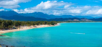 Aerial view of a beach on Oahu island, Hawaii, with turquoise waters, sandy shoreline, lush greenery, Ko olau mountains, and visitors enjoying the scene. photo