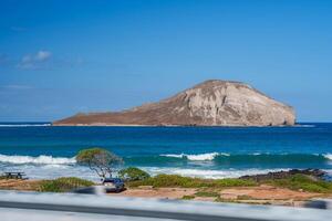 ver de Conejo de la isla Hazme me gusta forma apagado de oahu costa, con un costero parque presentando un picnic mesa, estacionado auto, y rocoso orilla. foto