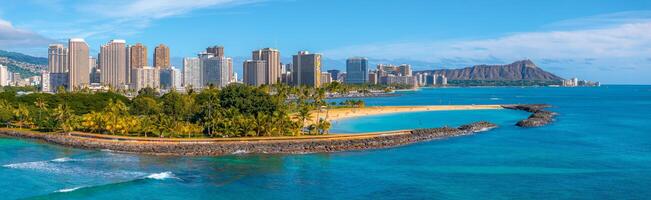 Aerial view of Waikiki Beach with turquoise waters, a sandy shore, palm trees, Honolulu's skyline, and the Diamond Head crater in the background. photo