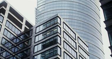 Facade of modern office buildings with large panoramic windows. Semicircular glass skyscraper in the business center of the city. in 4k, red komodo video