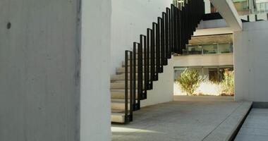 Street stairs in the courtyard of a glass office building, filming on a sunny day, there are no people in the . in 4k, red komodo video