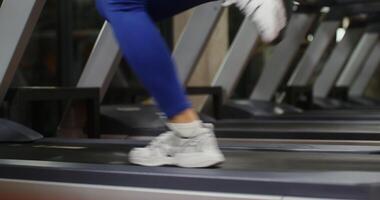 Running on a treadmill, female legs, close-up. Workout in the gym on exercise machines. The woman's face is not visible, unrecognizable person video