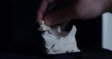 The orthodontist assembles the model of the jaw on a plaster substrate, adding piece by piece. Dental prosthetics, work on the creation of prostheses. in 4k, red komodo video