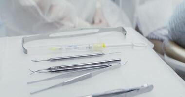A close-up of a dentist's table prepared for work with dental instruments laid out on it, a syringe with anesthesia and nozzles for a drill machine. in 4k, red komodo video