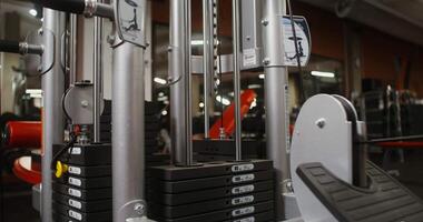 il pesi di un' moderno esercizio macchina siamo sollevato di il sforzo di un atleta, avvicinamento, Là siamo no persone nel il telaio. Palestra nel dettaglio video