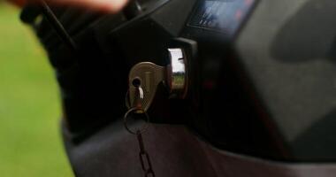 Close-up of a key in a tractor ignition switch. Male hand turns the key, starting the agricultural machine video