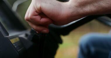A man's hand switches the control lever of an agricultural machine and turns the key in the ignition lock, close-up, the man's face is not visible video