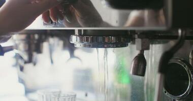 A woman inserts a container of pressed ground coffee into the coffee machine and starts it up. Female hands close up, no face video