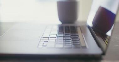 A man opens the lid of a laptop and begins to type text, close-up, no face in the frame, filming from the side video
