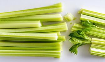 A bunch of celery and parsley are on a white counter photo
