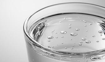 A glass of water with many small bubbles on the surface photo