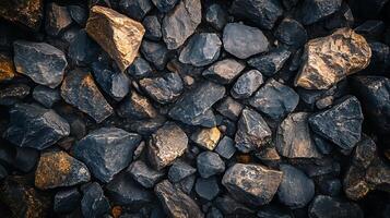 Pile of weathered and fractured rocks showing wear from erosion, revealing rich textures and colors under diffused lighting conditions. photo