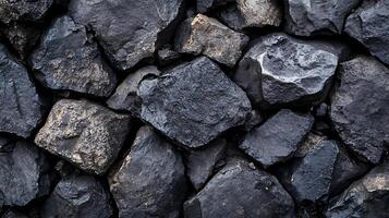 Dark rock surface with various shapes and textures. Rock pile of different sizes and depths is a stunning sight to behold. photo