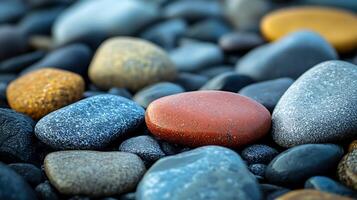 A macro image displaying various multicolored, smooth, oval-shaped beach rocks, creating a textured natural background pattern. photo