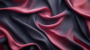 Woven fabric in deep charcoal gray and mauve pink tones drapes in elegant, flowing folds. Texture and color interplay create visual richness. photo