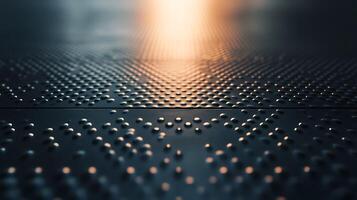 Metal floor with a studded texture reflects ambient light creating an abstract pattern. Dark, moody lighting accentuates the surface. photo