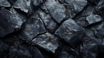 A dynamic composition of dark, fractured rock fragments, creating a rugged and textured surface. The interplay of light and shadow enhances depth. photo