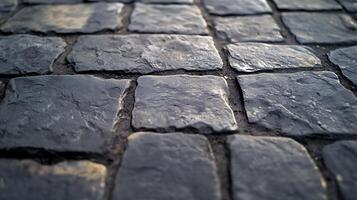Close-up of dark gray cobblestones with visible texture and crevices, creating a sense of depth and age in a paved surface. photo