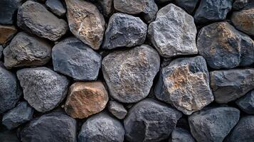 Detailed close-up of a wall constructed with large, dark stones, creating a rugged and textured surface. photo