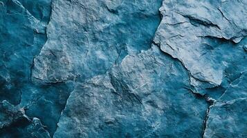 Textured rock background with layered, jagged stone fragments in shades of blue and grey. Abstract, natural pattern with rough texture. photo