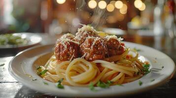 A plate of spaghetti with meatballs, garnished with parmesan cheese photo