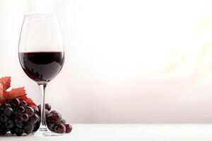 A beautifully styled glass of red wine sits elegantly next to fresh grapes and vibrant leaves, evoking a sense of indulgence and relaxation in a serene atmosphere. photo