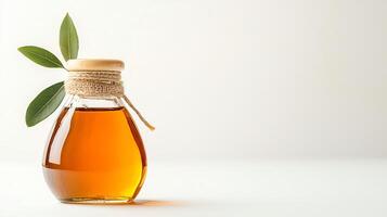 A beautifully styled glass bottle filled with golden oil, featuring a green leaf beside it. Perfect for culinary themes, health topics, or product promotions in the food industry. photo