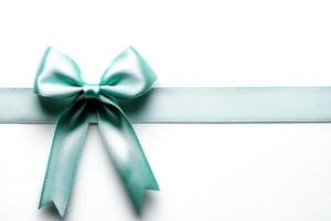 A beautiful, elegant teal bow adorns a soft ribbon against a clean white background, perfect for gift wrapping or decoration. Ideal for celebrating special moments and occasions. photo