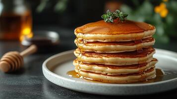 Stack of pancakes with honey and syrup on a plate photo