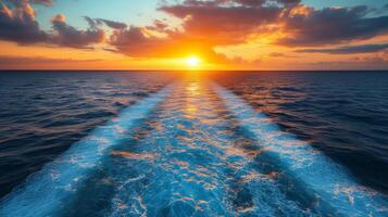 Sunset on the ocean with a wake trail photo