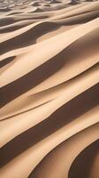 A high-detail image of sand dune patterns, highlighting the smooth curves and subtle shadow play across the surface. photo