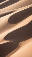 A close-up of sand dunes, emphasizing their wavy structure and the fine textures with soft, flowing shadows. photo