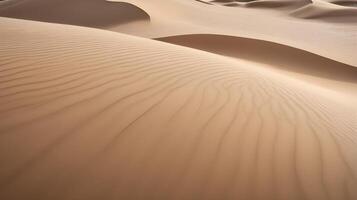 A detailed image of sand dunes, focusing on the smooth, wavy patterns and the soft shadows between the ridges. photo