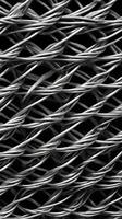 A sharp close-up of woven metal wire mesh, emphasizing its intricate, patterned structure. photo