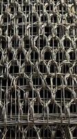 A high-resolution image of metal wire mesh, intricately interwoven into geometric shapes. photo