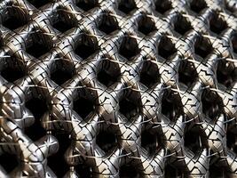 A geometric close up of interwoven metal wire mesh, forming repeating patterns. photo